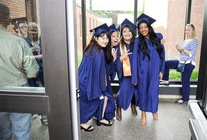 Riverland gradutes stop and pose for a quick photo through an open door on the way to sitting down for Riverland's commencement Friday afternoon at Riverland Community College. — Eric Johnson/Albert Lea Tribune