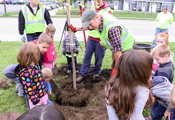 City of Albert Lea Parks Department employee Ben Bangert shows children at  Albert Lea Children’s Center the proper way to plant a tree in honor of Arbor Month. - Provided