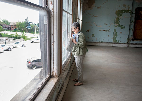 Marilyn Danielsen looks out a window of the former city hall and fire station Wednesday during the tour portion of the Historic Downtown Albert Lea Preservation Fair. - Colleen Harrison/Albert Lea Tribune