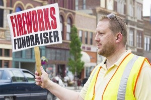 Ryan Cafourek was one of several volunteers standing out at the intersection of Broadway and Main Street on Friday to raise money for the Fourth of July fireworks. — Sarah Stultz/Albert Lea Tribune