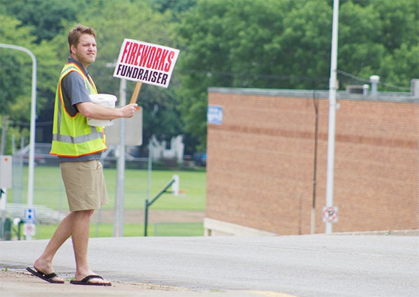 Jon Murray stands at the corner of Broadway and Main Street near Midwest Antiques on Friday to raise money for the Fourth of July fireworks fundraiser. — Sarah Stultz/Albert Lea Tribune