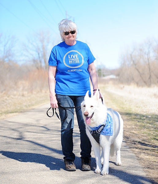 Lori Ashleson stands with her dog Willie, a German shepherd, on the Blazing Star Trail.