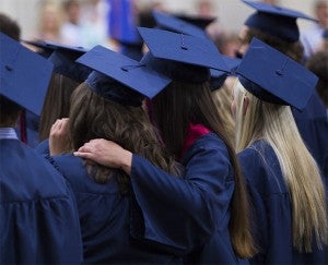 Students and friends comfort each other during their commencement processional Friday at Albert Lea High School. — Colleen Harrison/Albert Lea Tribune