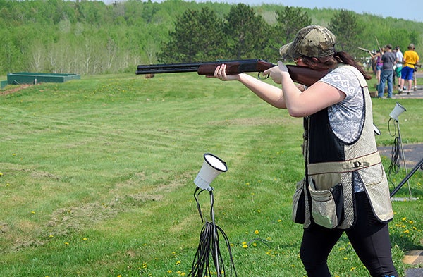 Hermantown senior Erin Flaig prepared to shoot at the Proctor Gun Club on May 27. When she says “pull,” the microphone below triggers the trap house, which fires a clay pigeon across the range. - Dan Kraker/MPR News 