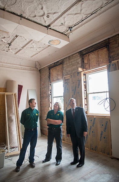 Worth Brewing Co. owners Peter Ausenhus and Margaret Bishop take Gov. Terry Branstad on a tour of their brewery's future expansion location Friday during the governor's stop in Northwood Friday. - Colleen Harrison/Albert Lea Tribune
