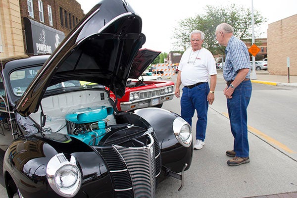 Ken Madson, left, and Ellwood Tukua talk next to a black 1940 Ford Coupe with a Cadillac engine on Saturday during Eddie Cochran Weekend. There were 114 cars entered. -  Sarah Stultz/Albert Lea  Tribune
