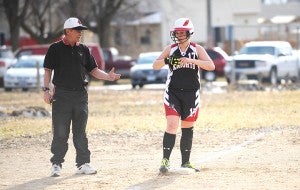 Cassie Gilster of Alden-Conger gives her batting gloves to coach Gary Nelson on April 11, 2014, against Waterville-Elysian-Morristown at Alden. After trailing 4-0 at the end of the first inning, Alden-Conger rallied to win 6-5 in eight innings. — Micah Bader/Albert Lea Tribune