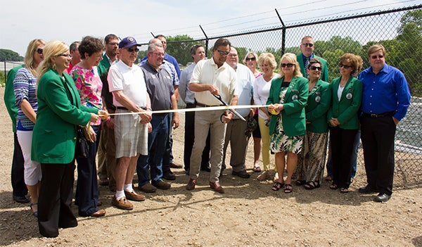 Gary Pestorious, chairman of the Shell Rock River Watershed District's board of managers, cuts a ribbon Friday during a ceremony for the new Albert Lea Lake dam and fish barrier. — Sarah Stultz/Albert Lea Tribune