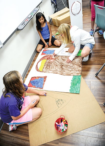Right, going clockwise: Lily Martin, 10, of Austin, Anna Gil of Albert Lea and Josanne Tempel of Hayfield work on their set design during Project E3 at I.J. Holton Intermediate School Thursday. - Eric Johnson/Albert Lea Tribune