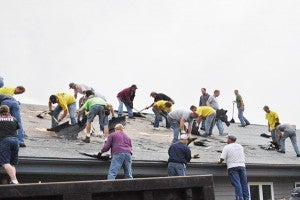 A group of volunteers work on a roof during Shinefest. - Provided