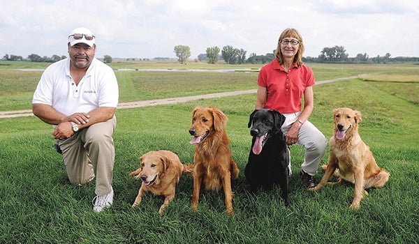 Rick and Andrea McConico pose with four of their dogs, Finley, from left, Bond, Magnum and Teya at Old Oak Kennels, west of Blooming Prairie. -Eric Johnson/Albert Lea Tribune