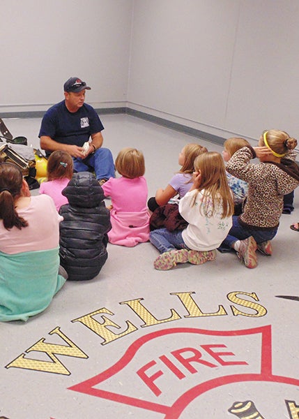 Fireman Mike Pyzick of the Wells Fire Department speaks to students of St. Casimir’s school about the importance of smoke alarms. The students also received a tour of the fire station by fireman Richard “Bucky” Brandenburg. - Provided