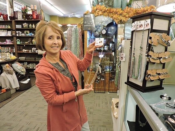 Rosalie Helgeson showcases a necklace in her store, Main Attractions, which is one of the businesses sponsoring the Holiday Trends & Friends event. - Kelly Wassenberg/Albert Lea Tribune