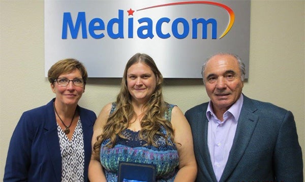 Kristina Hawk, center, receives the Call Center Employee of the Year award from Mediacom Senior Manager Karen Vanderhoof and Mediacom Chairman and CEO Rocco Commisso. - Provided