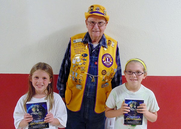The third grade class of St. Casimir’s School in Wells were recently gifted with dictionaries from the Wells Lions Club. The dictionaries were personally given to each student by Lion Larry Majeski to bolster the students’ academic success. Shown with their dictionaries and Lion Majeski are SCS students, Brooklyn Miller and Emma Johnson. -Provided 