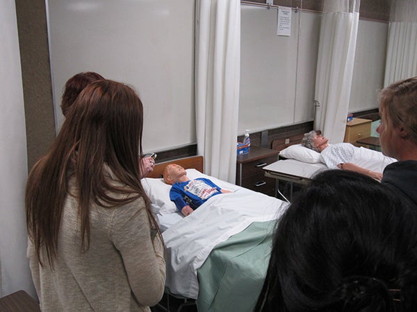 Jane McKinley, instructor at Riverland Community College in Austin demonstrates the simulation mannequin last week during an event to educate people about health care jobs available in the area. - Provided