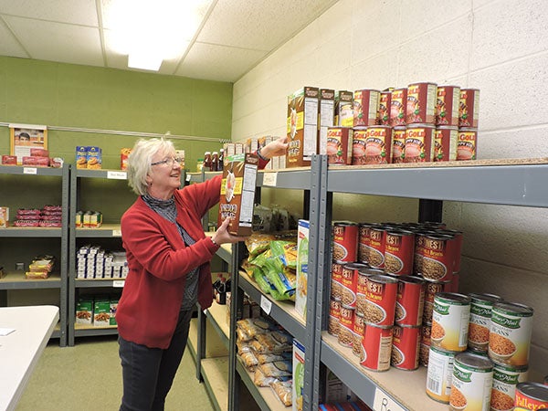 Gail Batt stocks shelves at Trinity Lutheran Church, which currently hosts the New Richland Area Food Shelf. - Kelly Wassenberg/Albert Lea Tribune