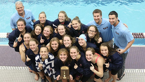 The Albert Lea girls’ swimming team celebrates with the trophy for winning the Big Nine Conference title Saturday at the University of St. Thomas in St. Paul. — Provided