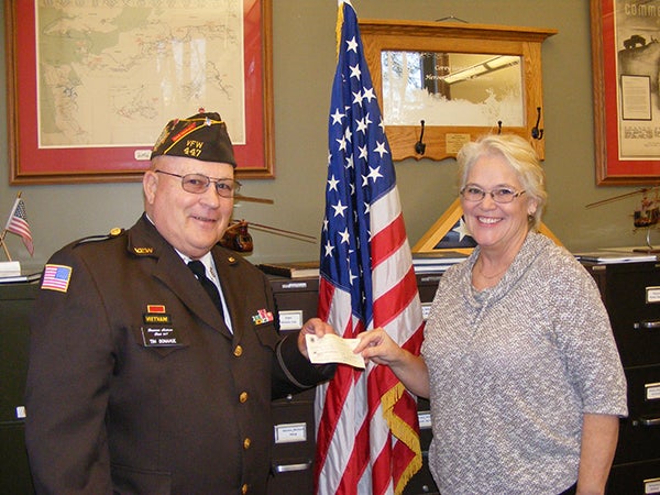 The Albert Lea Lions donate $75 to the Veterans of Foreign Wars color guard in honor of Veterans Day. Pictured are Lion Irene Anderson presenting the check to Tim Donahue of the VFW. - Provided