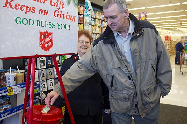 Gary Stephenson donates to the Salvation Army Friday morning at Hy-Vee. Volunteer Elsie Cline is shown in the background. - Sam Wilmes/Albert Lea Tribune