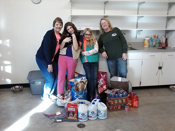 Girl Scouts from Troop 44836 deliver food, cleaning supplies and other items to the Freeborn County Humane Society. The girls used money raised from cookie sales to purchase items for the shelter. - Provided