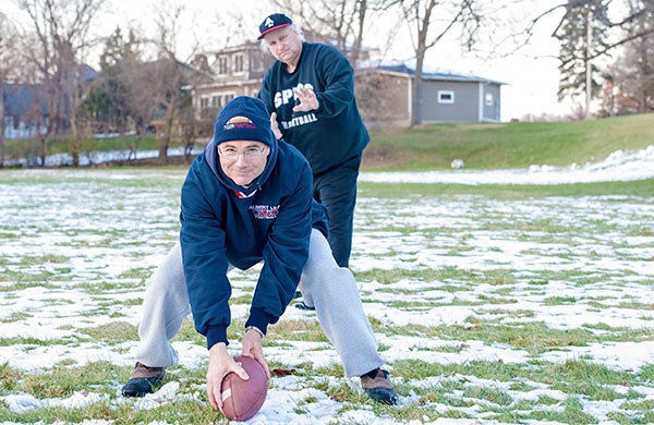 Rick Harves, one of the founding members of the Turkey Bowl, looks to snap the ball to Steve Roche, who has played in the game each year since 1971, Tuesday at lower Abbott Field in Albert Lea. - Micah Bader/Albert Lea Tribune