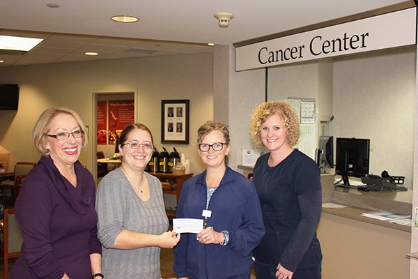 Karen Szymanowski and Kris Bartley, members of the Albert Lea Community Theater board of directors and “Calendar Girls” actors, present a check for $1,400 to registered nurse Kellie Peterson and radiation therapist Jenni Mattson of the cancer center at Mayo Clinic Health System in Albert Lea. The $1,400 represents 10 percent of the ticket proceeds from the October play “Calendar Girls.” -Provided