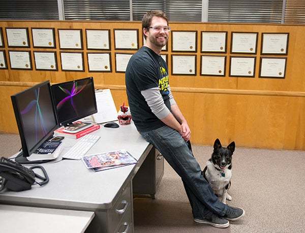 Micah Bader, pictured at his desk with his dog Josie, will finish his last day as the Tribune’s sports editor on Friday. Colleen Harrison/Albert Lea Tribune