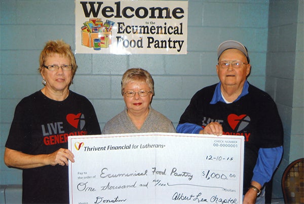 Hazel Spiering, left, and Les Anderson, far right, present a check for $1,000 from Thivent Financial to the Ecumenical Food Pantry. -Provided