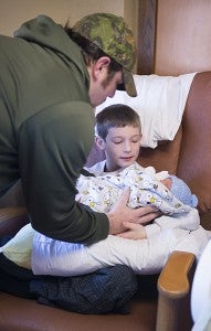 Aaron Bromeland helps son Brody Bromeland hold his newborn brother, Odin Bromeland. - Colleen Harrison/Albert Lea Tribune