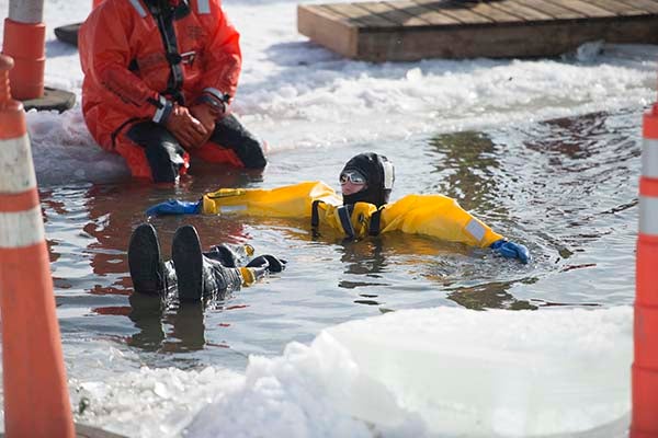 A firefighter floats in Fountain Lake while waiting for participants to get ready for the Blue Ice Plunge during The Big Freeze Saturday at Edgewater Park. — Colleen Harrison/Albert Lea Tribune