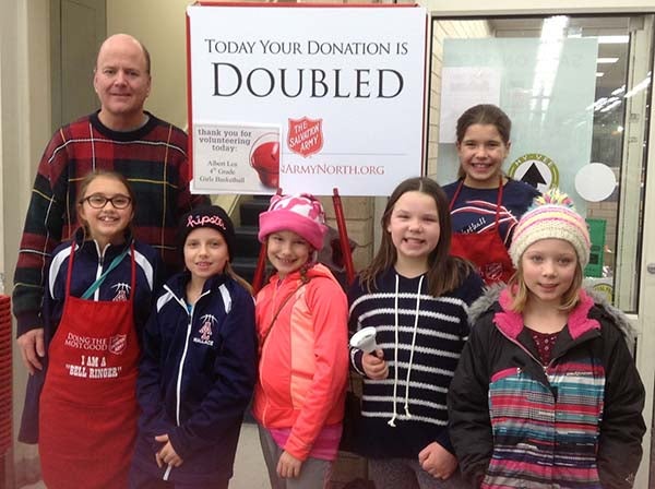 The fourth-grade girls traveling basketball team  rang the bells for the Salvation Army on the Saturday before Christmas. In front, from left, are Hannah Willner, Elizabeth Wallace, Alexis Jones, Olivia Wegner and Jalen Boss. In back from left are Tom Jones and Emily Komoszewski. — Provided