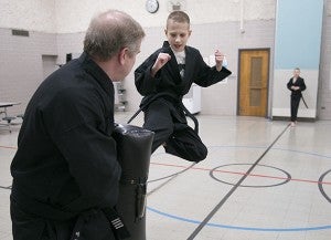 The twin brothers practice some kicks with their instructor at Halvorsen Elementary School. - Colleen Harrison/Albert Lea Tribune