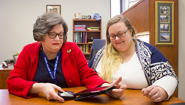 Albert Lea Public Library Director Peggy Havener and graphics librarian Michelle Gurung model the hot spot and tablet that will be available later this month. - Sam Wilmes/Albert Lea Tribune