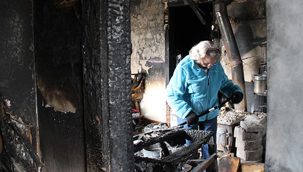 Gloria Lashbrook looks through debris from a fire at 803 Bridge Ave. in Albert Lea Wednesday morning. — Sarah Stultz/Albert Lea Tribune