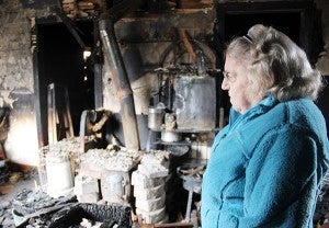 Gloria Lashbrook looks out over the damage from a fire last week that destroyed a house at 803 Bridge Ave. — Sarah Stultz/Albert Lea Tribune