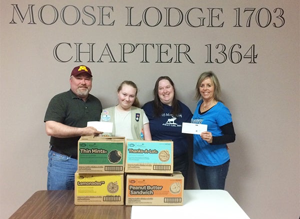 The Loyal Order of the Moose Lodge 1703 and the Women of the Moose Chapter 1364 makes a donation to Girl Scouts Troop 43224 to purchase Girl Scout cookies for veterans. Steve Svendsen, far left, and Jackie Carstens, far right, present checks for the cookies to Megan and Theresa Raatz, center. - Provided