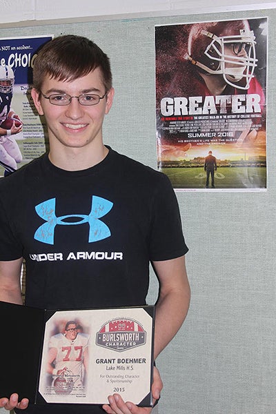 Lake Mills’ Grant Boehmer holds the certificate he received as a recipient of the Brandon Burlsworth Character Award. Boehmer is pictured in front of a promotional poster for “Greater,” a movie depicting Burlsworth’s life that is set to be released this summer. - Terry Gasper/Lake Mills Graphic