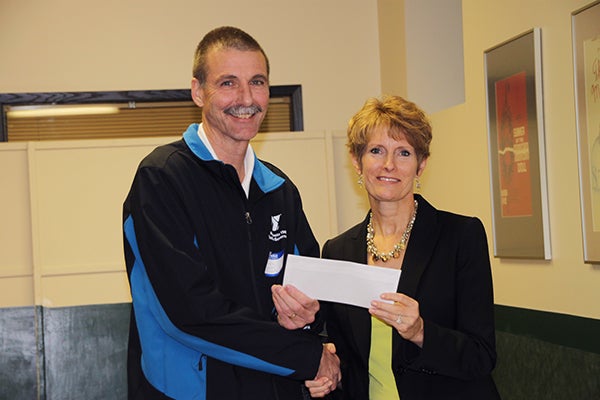 Dennis Dieser, from Albert Lea YMCA, receives a donation from Jillian Peterson, board chairwoman of the Freeborn County Community Foundation. - Provided