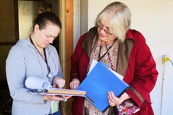 Michele Anderson, left, and Lisa Smestad review an inspection report for a north Minneapolis rental property that has lead contamination. A child in the home was poisoned by lead paint and the city of Minneapolis is using a federal HUD grant to help clean up the property. - Lorna Benson/MPR News