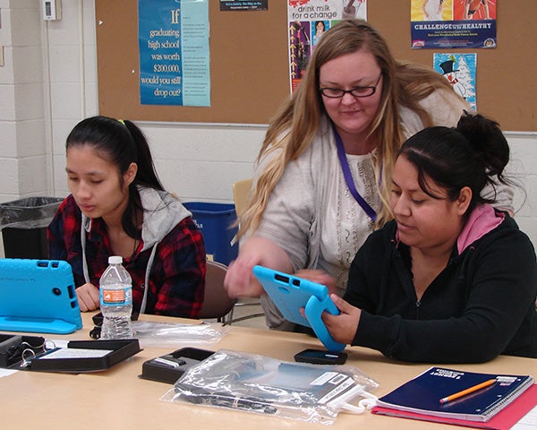 La Tay Tha, left, and Lourdes Linares, right, are aided by Michelle Gurung in learning how hotspots work. - Provided