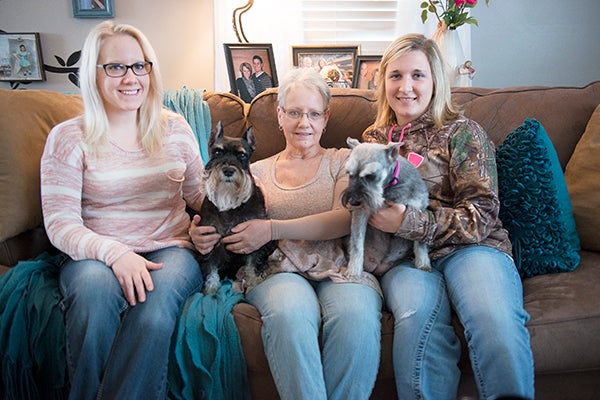 From left, Jena Indrelie, Marsha Indrelie and Sam Remakel hold Indrelie family dogs Molly and Ana. Marsha Indrelie was diagnosed with breast cancer in 2015. Her husband, Craig Indrelie, was diagnosed with an inoperable aortic aneurysm in 2012 and their daughter, Jena Indrelie, was diagnosed with an incurable neurological disorder in 2013. Remakel and other family friends are organizing a benefit for the Indrelies. - Colleen Harrison/Albert Lea Tribune