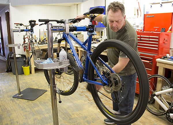 Dan Lestrud checks a tire on a bicycle at Broadway Bike Co. on Friday. Lestrud opened the shop last month. - Sarah Stultz/Albert Lea Tribune  