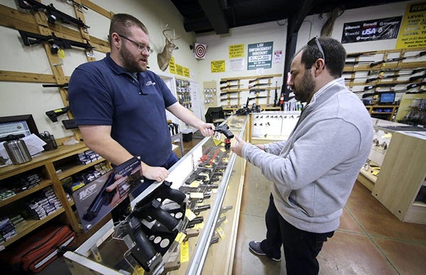 Minnesota lawmakers held a hearing for gun control measures on Tuesday, but the two bills aren’t going anywhere this session. Pictured, a man shops for a handgun in Spring, Texas. - David J. Phillip/AP
