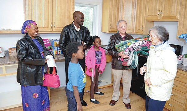 Bruce and Liz Richardson give quilts to Gabait Nagid and Nasra Damin and their children Sabreen and Saber during their house dedication through Habitat for Humanity Thursday afternoon. - Eric Johnson/Albert Lea Tribune
