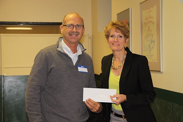 David Peterson from AZ-One accepts a donation from Jill Peterson, chairwoman of the Freeborn County Community Foundation for the Community Cornerstone roofing project. - Provided