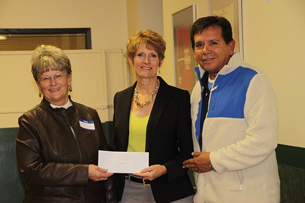 Pat Mulso and Miguel Garate from the Taste of Heritage Festival accept a donation from Jillian Peterson board chairwoman of the Freeborn County Community Foundation. - Provided