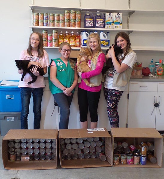 Kendall Bolinger, Lincoln Giles, Madison Doyle and Raine Dana, from Girl Scouts Troop 44836, make a donation food and cleaning supplies to the Humane Society of Freeborn County. The items were purchased with some of the troop’s proceeds from cookie sales. - Provided