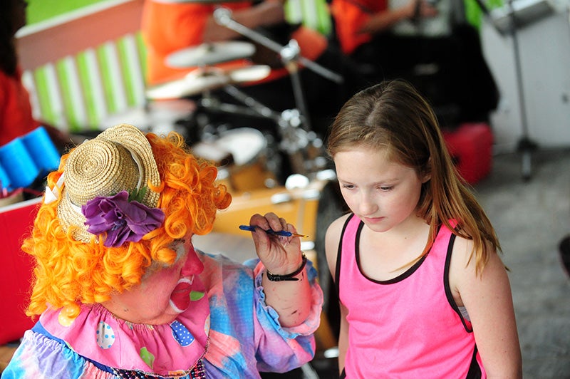 Half Pint the Clown paints a cupcake on the face of Audrey Heard of Lyle during Glenville Days in 2013. - Brandi Hagen/Albert Lea Tribune