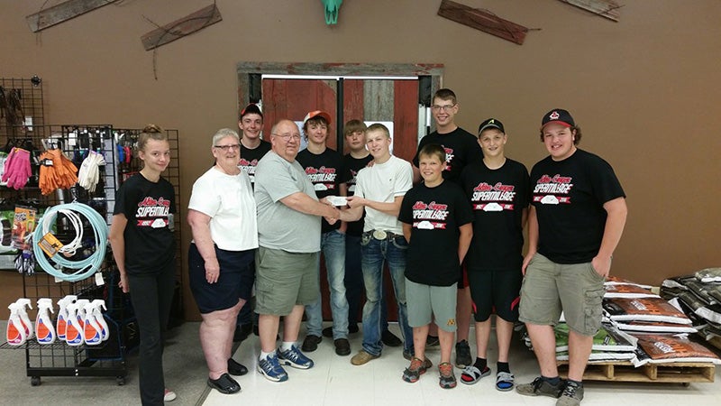 Dave and Karen McKean of McKean’s Produce present a check to the Alden-Conger Supermileage Team for $372. The couple donated $4 from every hanging basket they sold towards its trip to London. Team members in the picture Shayanne Sailor, Logan Sailor, Gage Sailor, Isaac Sorensen, Sam Jacobs, Ryan Wallin, Jacob Wallin, Garrick Steele and Josh Majerus. The McKean’s sell flowers and vegetables at their residence in Alden. -Provided